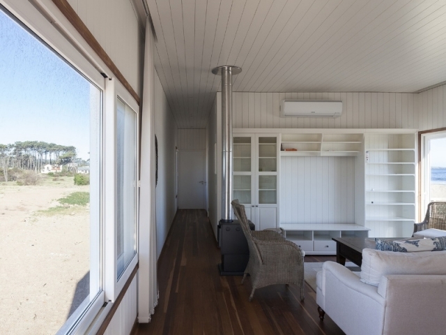 Casa de la playa en Chihuahua, Colle-Croce (Brasil) - El living cómodo y acogedor con sillones, modular y estufa.